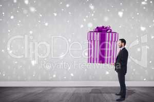 Composite image of stylish man with giant gift