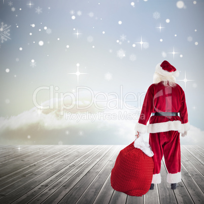 Composite image of santa with sack of gifts