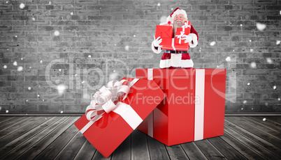 Composite image of santa standing in large gift