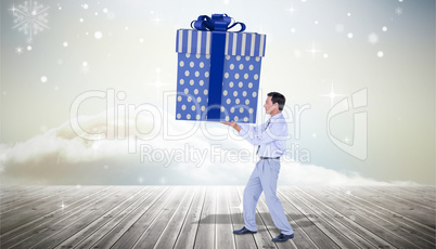 Composite image of stylish man with giant gift