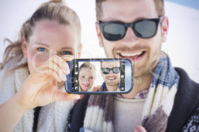 Composite image of hand holding smartphone showing