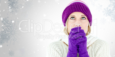 Composite image of freezing young woman wearing gloves looking u