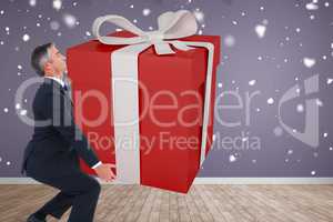 Composite image of stylish man with giant gift