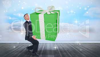 Composite image of stylish man with giant gift