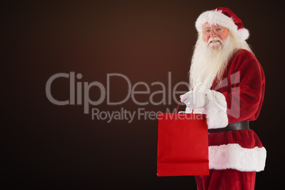 Composite image of santa carries red gift bag