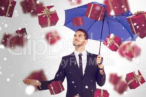 Composite image of cheerful businessman holding umbrella with ha