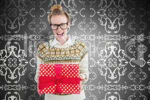 Composite image of excited geeky hipster holding present