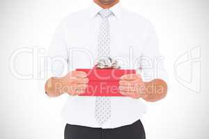 Composite image of businessman holding his hands out