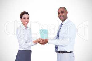 Composite image of business colleagues holding plant and looking