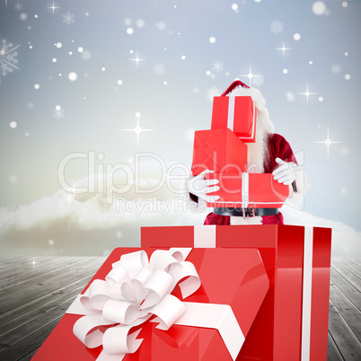 Composite image of santa standing in large gift