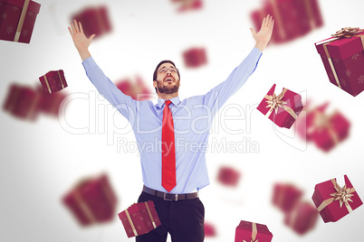 Composite image of happy cheering businessman raising his arms