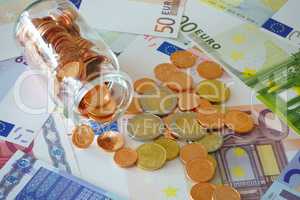 Münzen im Glasfäschchen und Euro Geldscheine