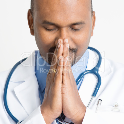 Close up Mature Indian doctor praying