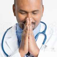Close up Mature Indian doctor praying