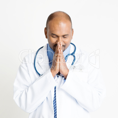 Mature Indian doctor praying