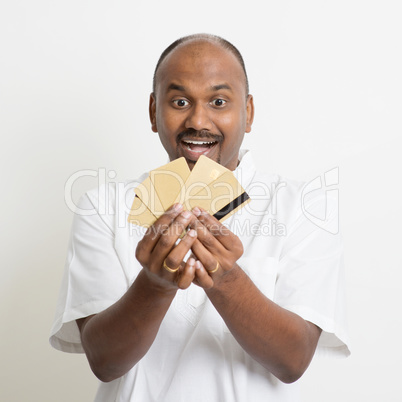 Mature casual business Indian man holding many credit cards