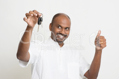 Indian man holding car key and thumb up