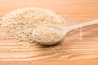 Organic natural sesame seeds in the wooden spoon on wood table