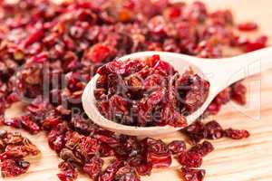 Dry red barberry spices in the wooden spoons