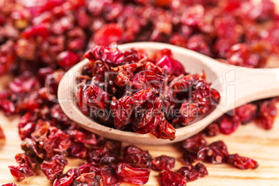 Dry red barberry spices in the wooden spoons