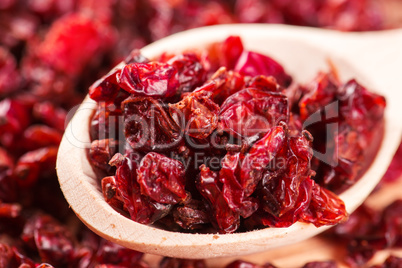 Dry red barberry spices in the wooden spoons