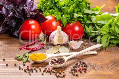 Raw vegetables, basil and spices on the wood table