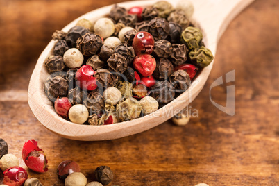 Pepper seeds in wooden spoon on wood table