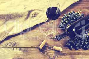 Bottle of white wine, grape and corks on wooden table