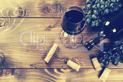 Bottle of white wine, grape and corks on wooden table