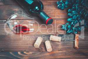 Bottle of white wine, grape and corks on wooden table