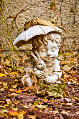 Boy with Umbrella Statue Topped by Leaves