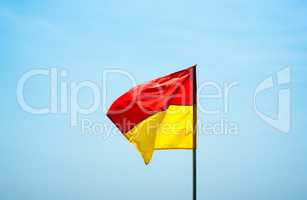 Red and yellow swimming safety flag flapping