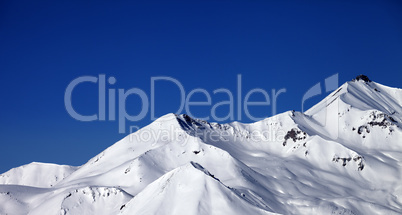 Panoramic view on snowy winter mountains and clear blue sky in s