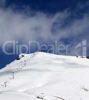 Ski slope and ropeway at sunny winter day