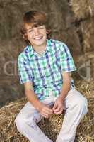 Young Happy Boy Sitting Smiling on Hay Bales