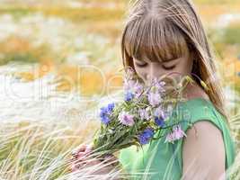 Young sensual girl smelling a bouquet of wildflowers