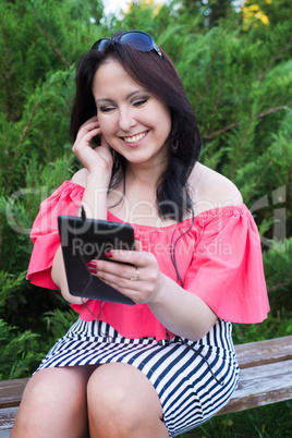 Smiling brunette listening to music with tablet