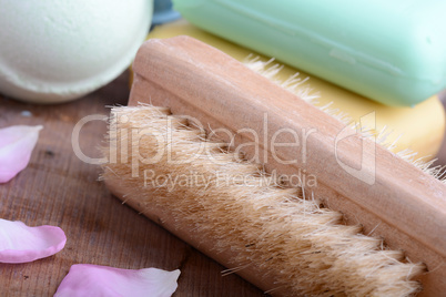 soap, comb, sea salt, spa stones and flower petals on wooden table, close up
