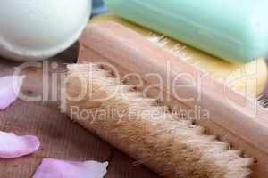 soap, comb, sea salt, spa stones and flower petals on wooden table, close up