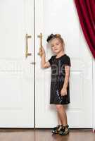 Little Girl in Evening Dress Standing near Door