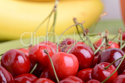 Close up of a fresh pile of fruit consisting of cherries and bananas