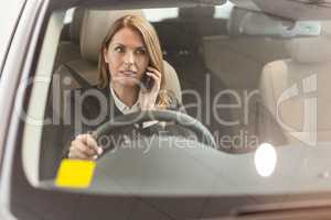 Smiling businesswoman having a phone call while sitting in a car