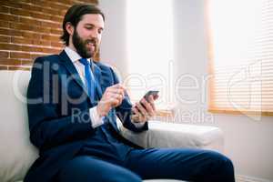 Businessman texting on the couch
