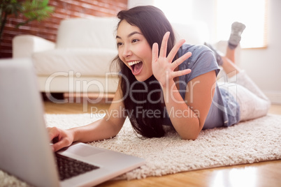 Asian woman using laptop on floor