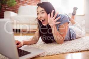 Asian woman using laptop on floor