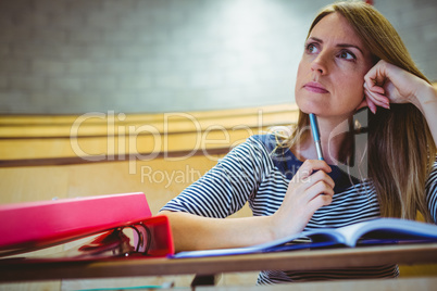 Mature student taking notes in lecture hall