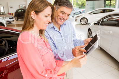 Smiling couple choosing the color of their new car