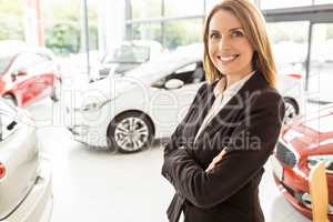 Smiling saleswoman standing with arms crossed