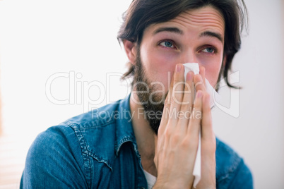 Sick man blowing his nose