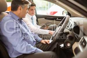 Businessman pointing a car interior